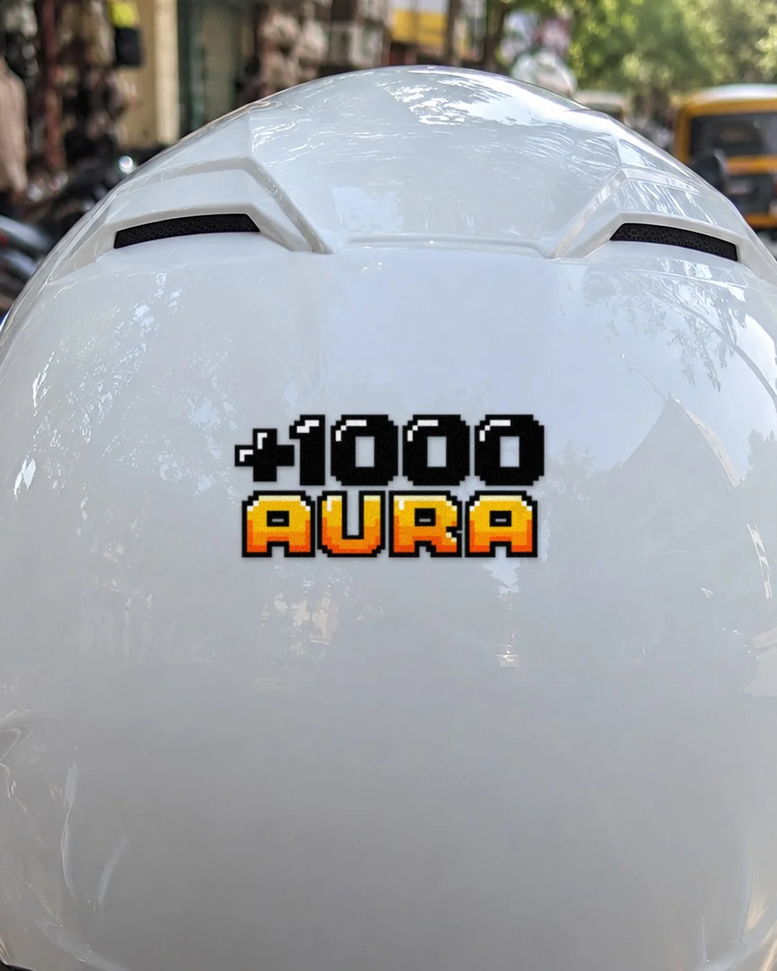 +1000 Aura bike patch in black ink on a helmet