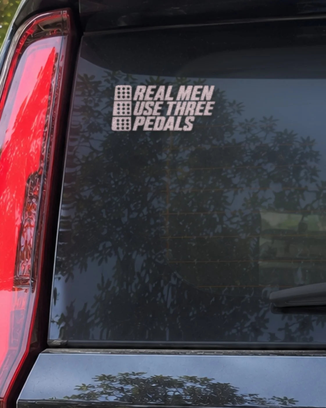 Three Pedals car patch in white on a car