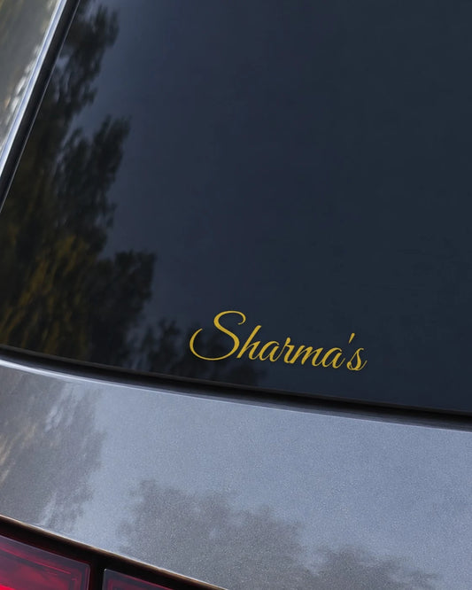 Custom name car patch in gold script on a rear windshield