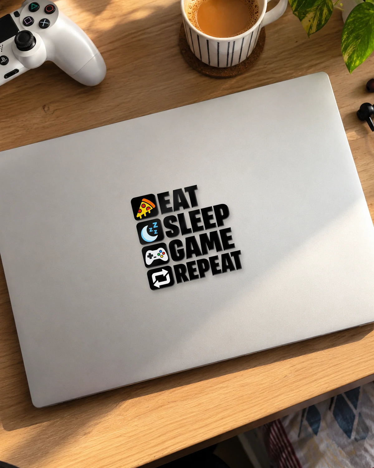 Eat Sleep Game Repeat gamer patch in black ink on a laptop