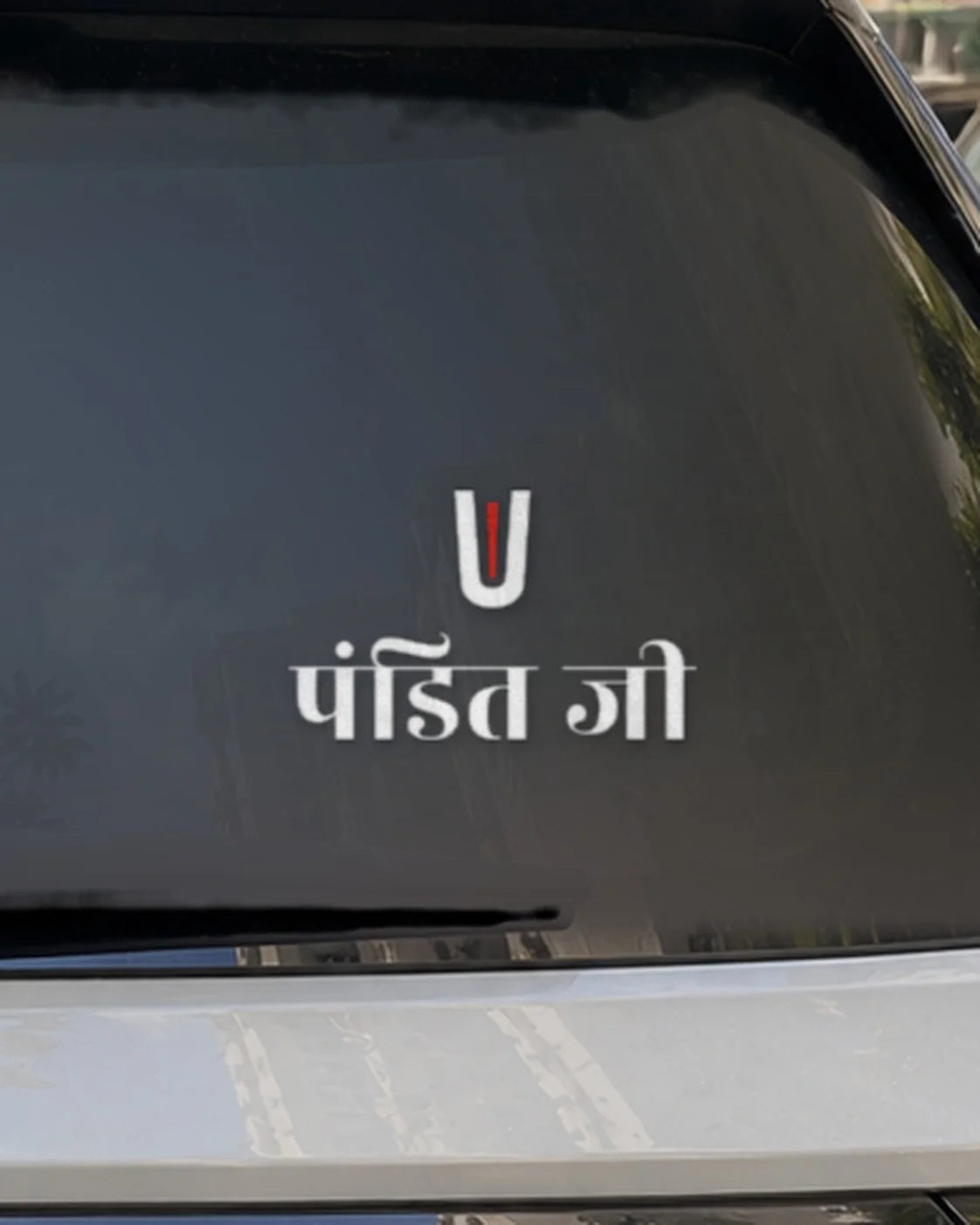 Pandit Ji car patch on a car rear glass