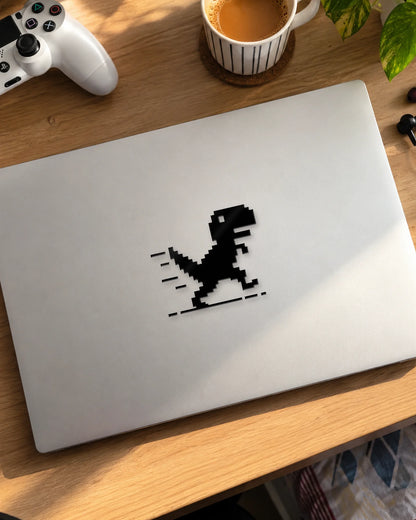 Pixel Dino gamer patch in black ink on a laptop