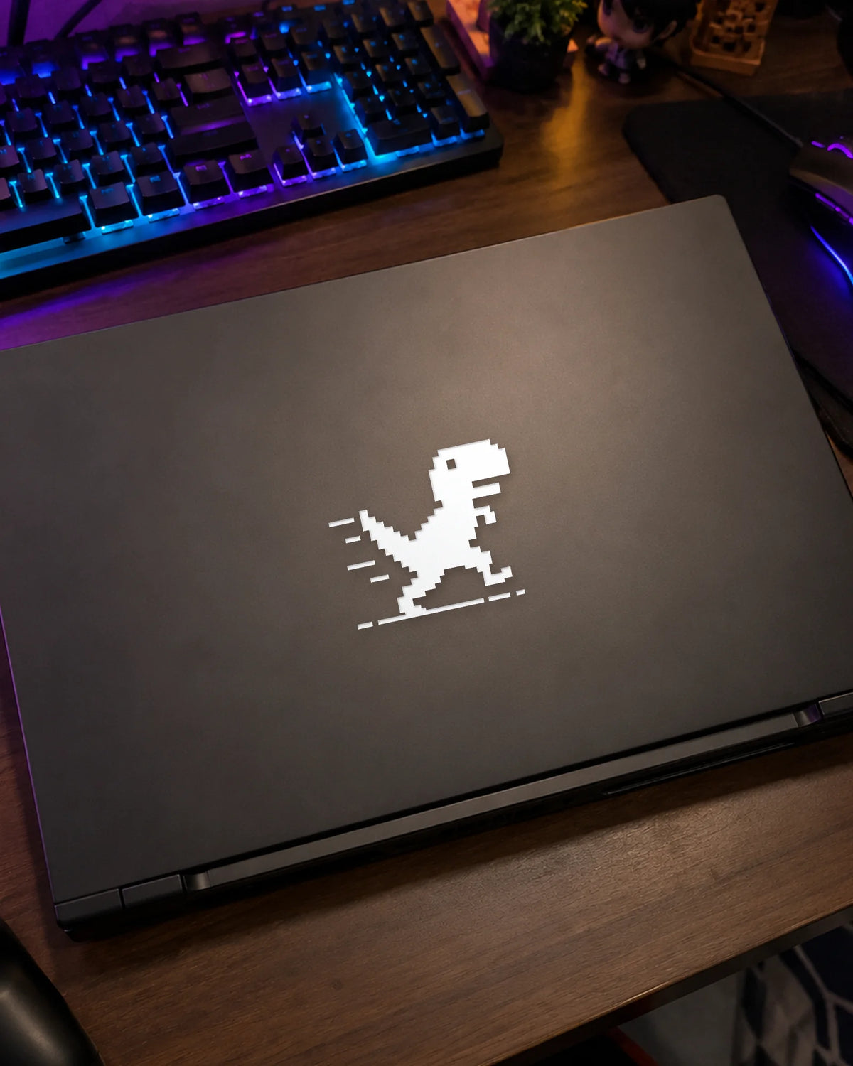 Pixel Dino gamer patch in white ink on a gaming laptop
